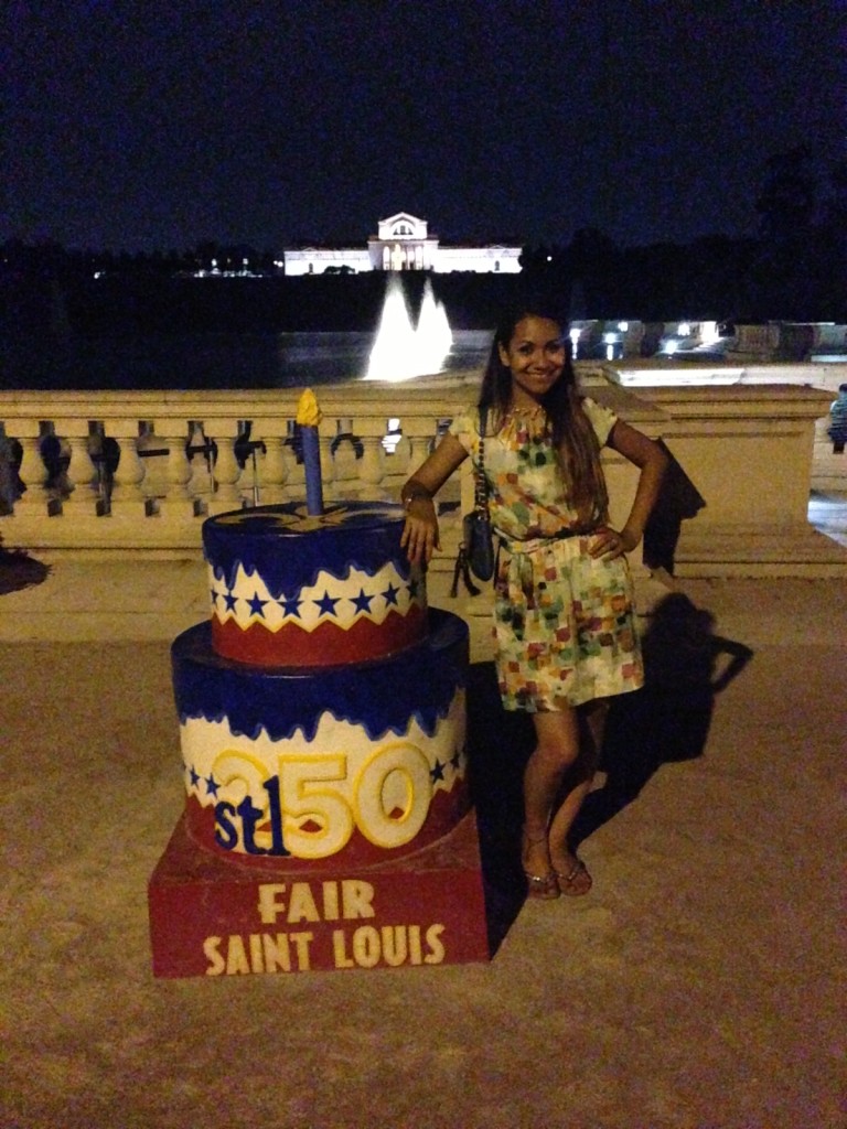 Bolo comemorativo dos 250 anos de St. Louis. Ao fundo, o Worlds Fair Pavillion, local onde ocorreu a Exposição Universal de 1904 no Forest Park.